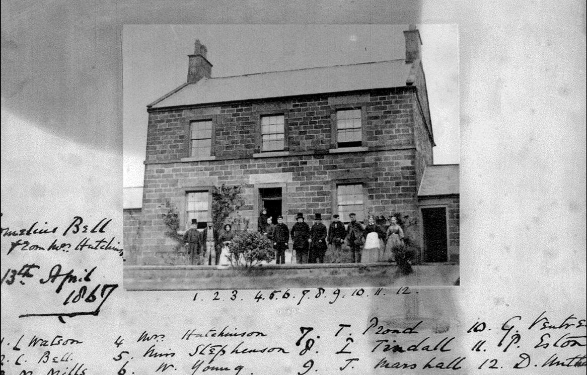 A group of people standing outside a brick house
Description automatically generated